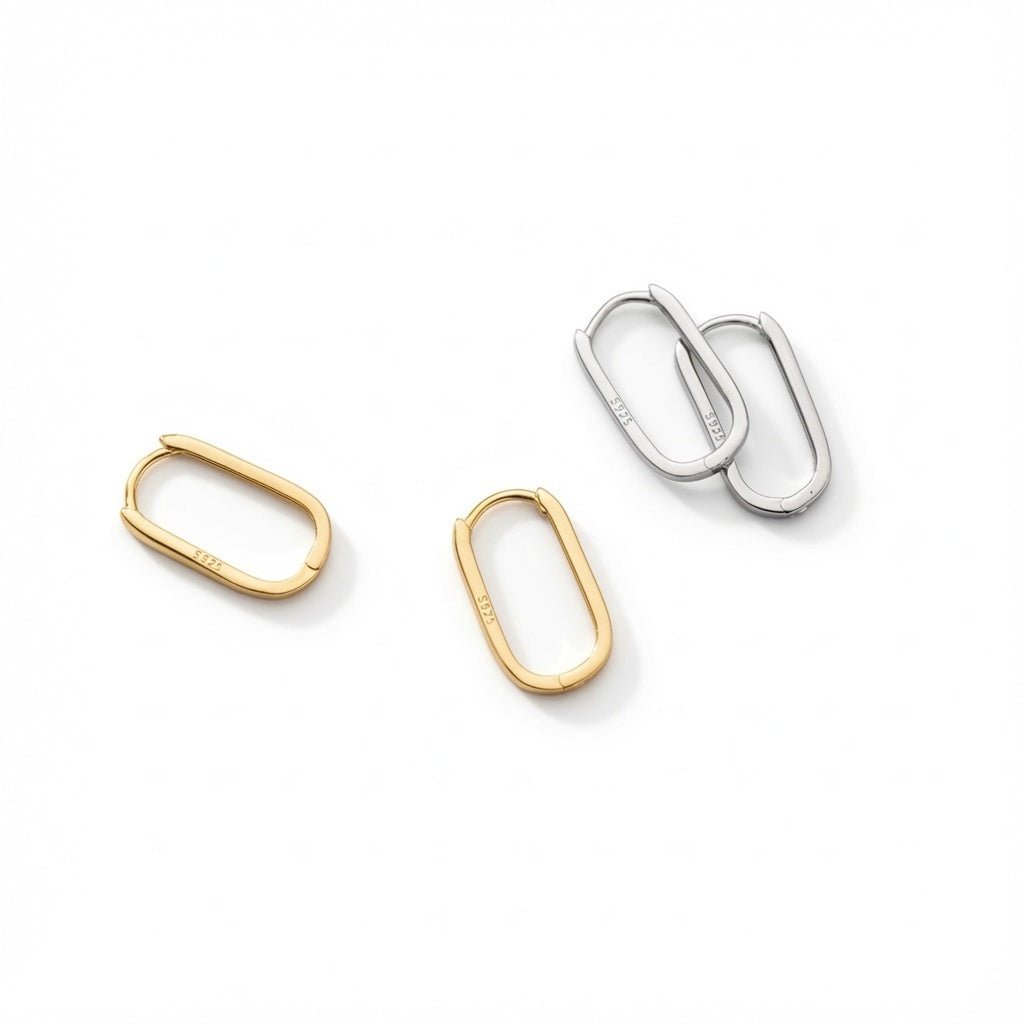 Two pairs of oval hoop earrings on a white background, one pair in 14ct gold and one pair in sterling silver, showing the S925 hallmark stamp