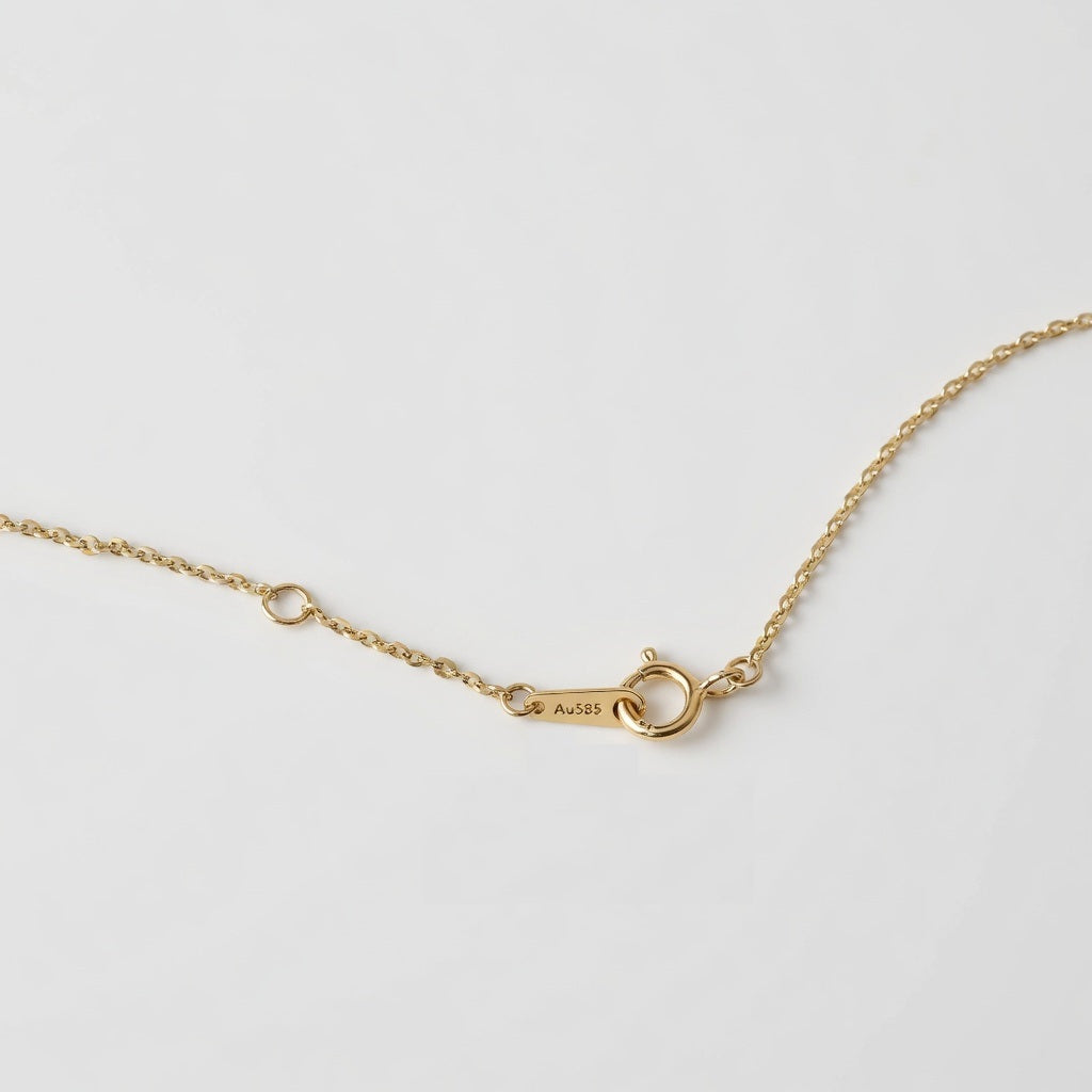 14ct solid gold cable chain necklace closed up showing Au585 hallmark on a light background