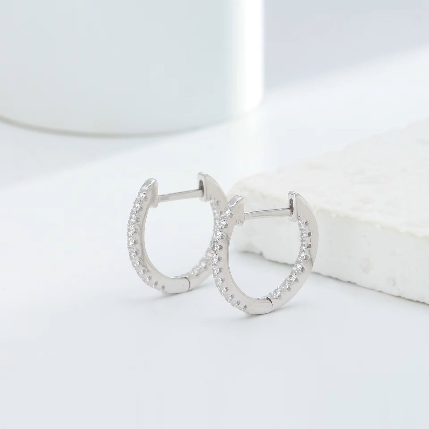 925 sterling silver crystal hoop earrings with cubic zirconia stones on white marble background