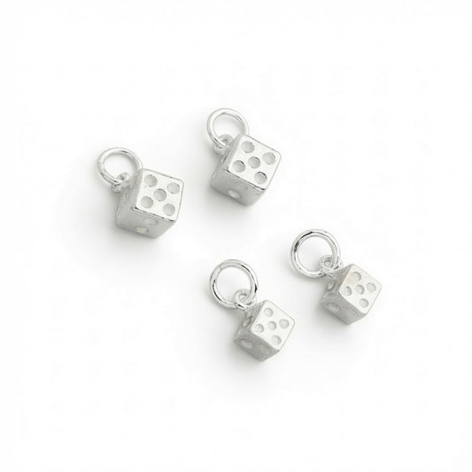 Four 925 sterling silver dice charms 6.5 mm and 5 mm with attached jump rings, arranged on a plain white background.