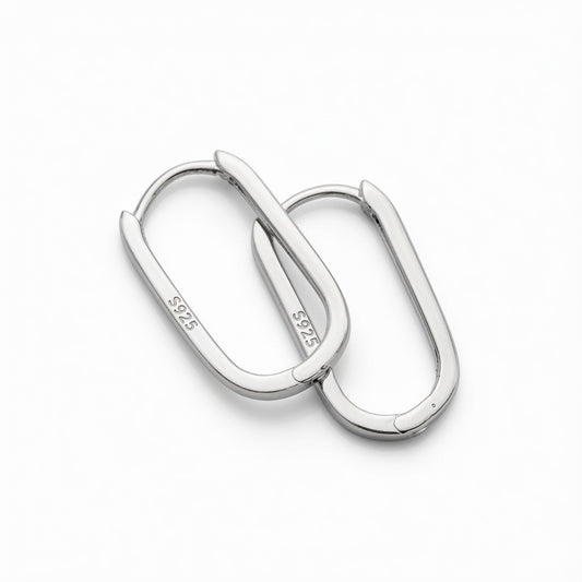 Close-up of two sterling silver oval hoop earrings on a white background, showing the S925 hallmark and hinged closure detail