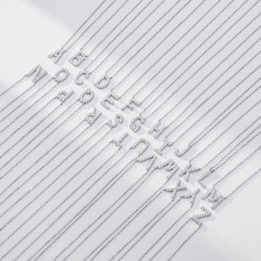 Silver letter necklaces with chain links on a light gray background