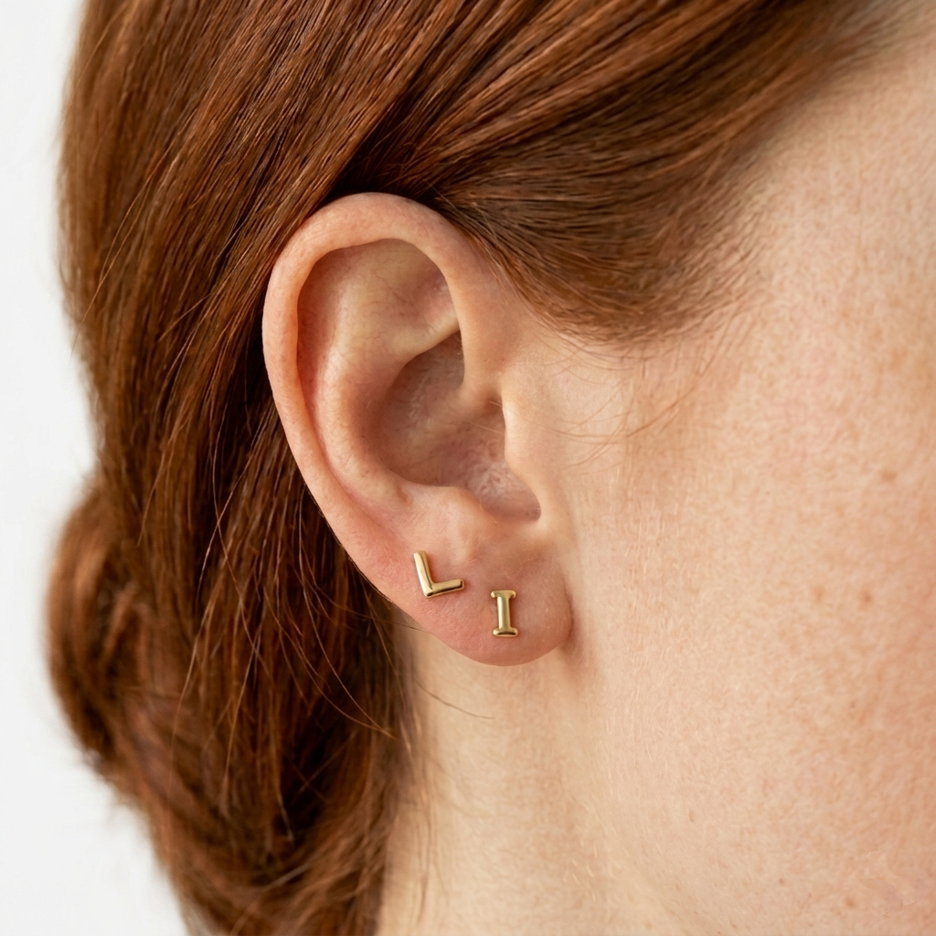 Gold vermeil initial letter stud earrings worn on ear — personalised jewellery by Agnes and Simon